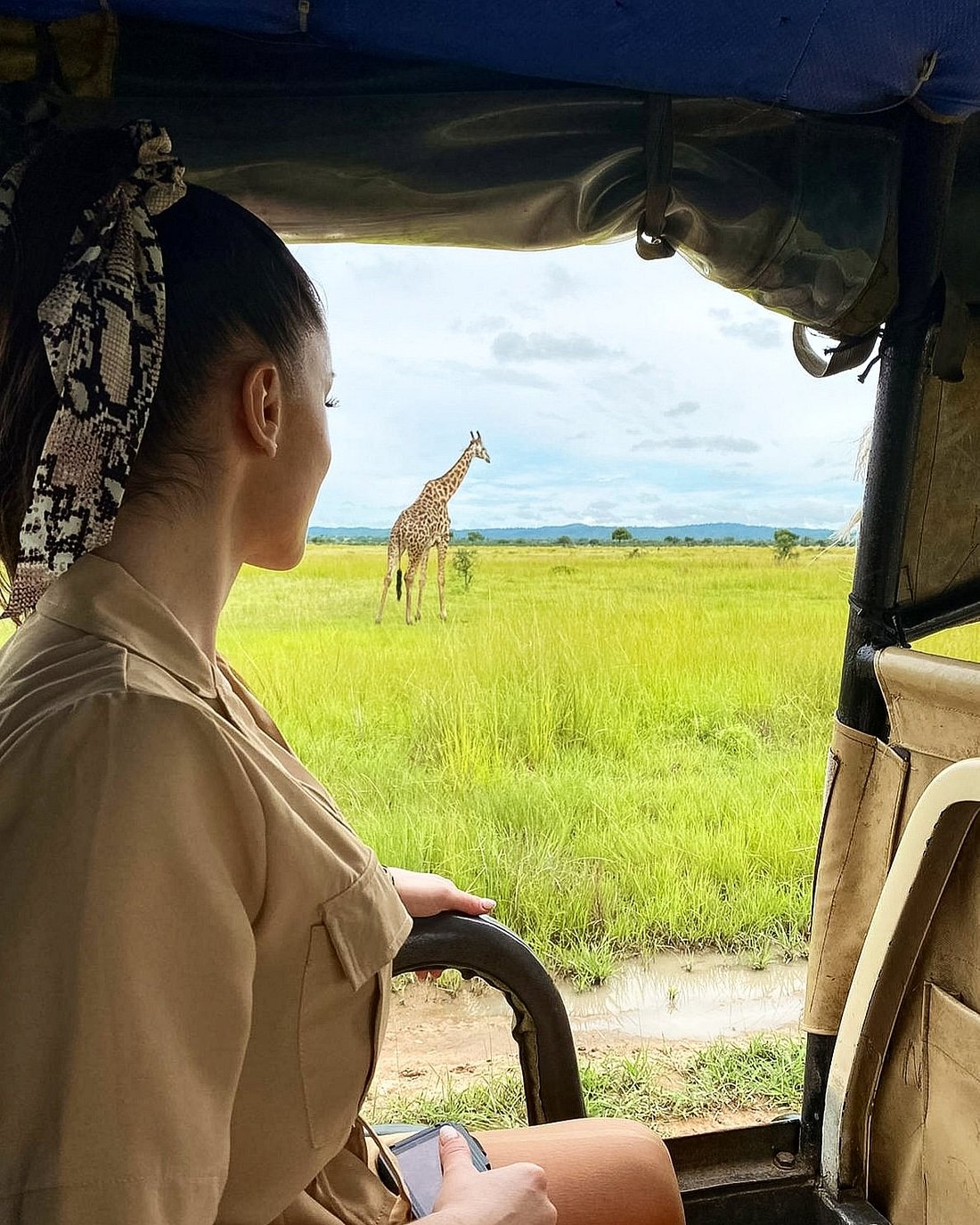 Open grassland at golden hour seen from an open-sided safari vehicle