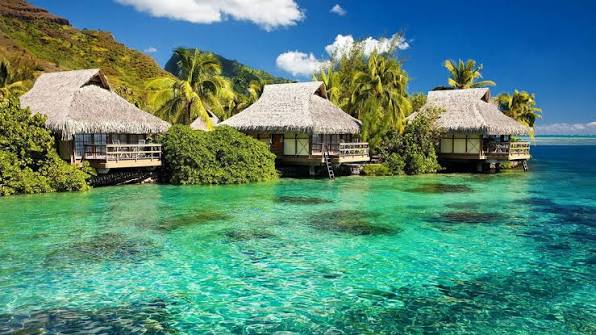 Overwater bungalows on stilts above clear turquoise water